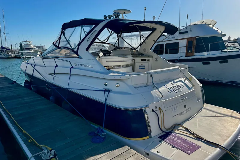 Slide: The Image of 2004 Regal Commodore 3860 yacht docked at marina, featuring sleek design and spacious deck. - 7