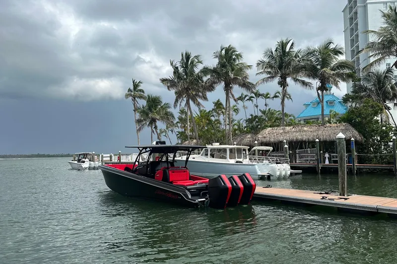 The Image of 2026 Nor-Tech 340 Sport Center Console docked by palm trees under cloudy skies. - 0