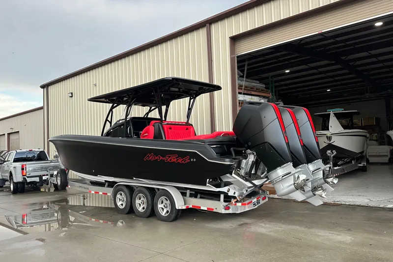 Slide: The Image of 2026 Nor-Tech 340 Sport Center Console boat with triple engines on a trailer. - 22