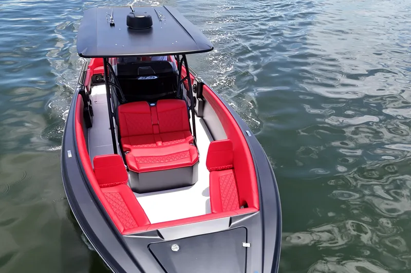 Slide: The Image of 2026 Nor-Tech 340 Sport Center Console boat with red seating on water. - 24