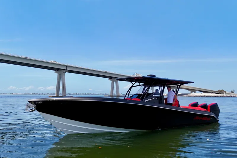Slide: The Image of 2026 Nor-Tech 340 Sport Center Console boat cruising near a bridge on a sunny day. - 3