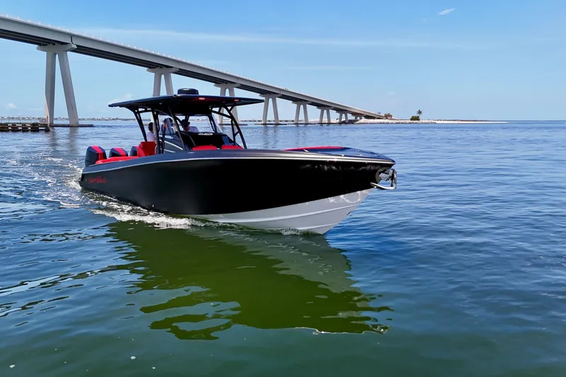 Slide: The Image of 2026 Nor-Tech 340 Sport Center Console boat cruising under a bridge on a sunny day. - 9