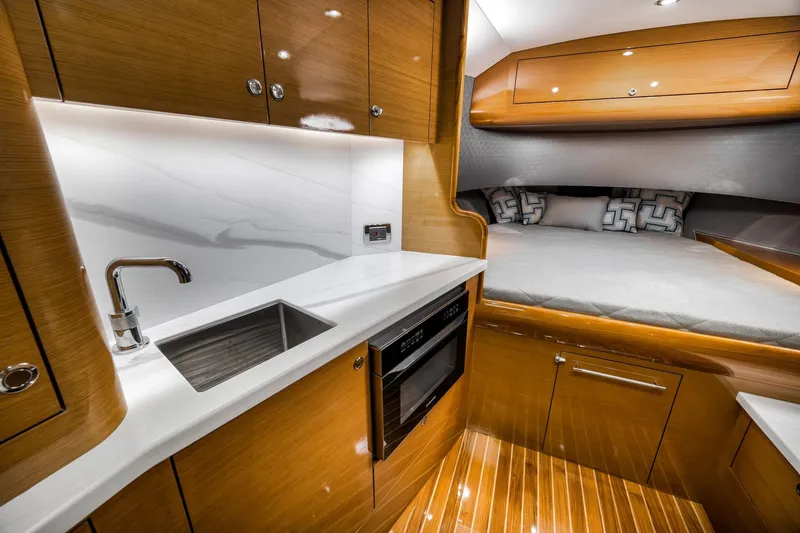 Slide: The Image of Luxurious interior of 2022 Winter Custom Yachts 38 Walk Around, featuring a sleek kitchenette and cozy sleeping area. - 24