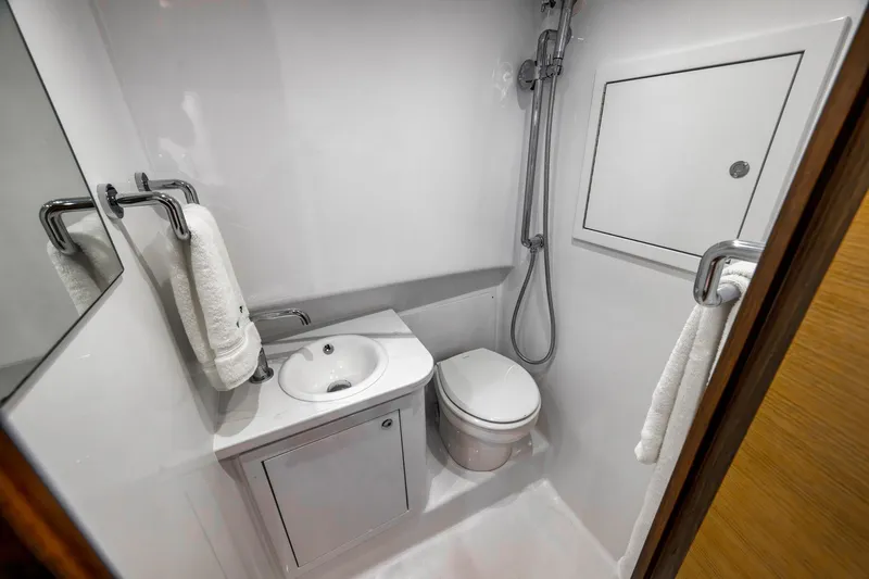 Slide: The Image of Compact bathroom in 2022 Winter Custom Yachts 38 Walk Around, featuring shower, sink, and toilet. - 27