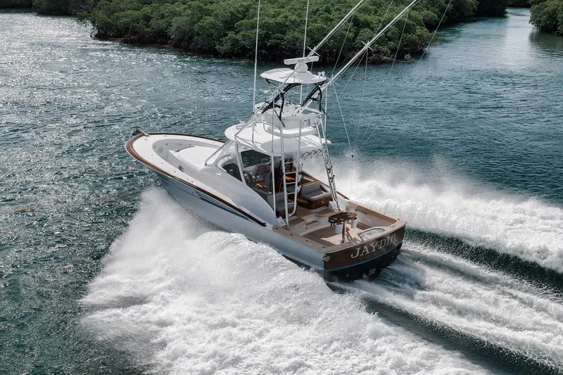 Slide: The Image of 2022 Winter Custom Yachts 38 Walk Around cruising through water, surrounded by lush greenery. - 5