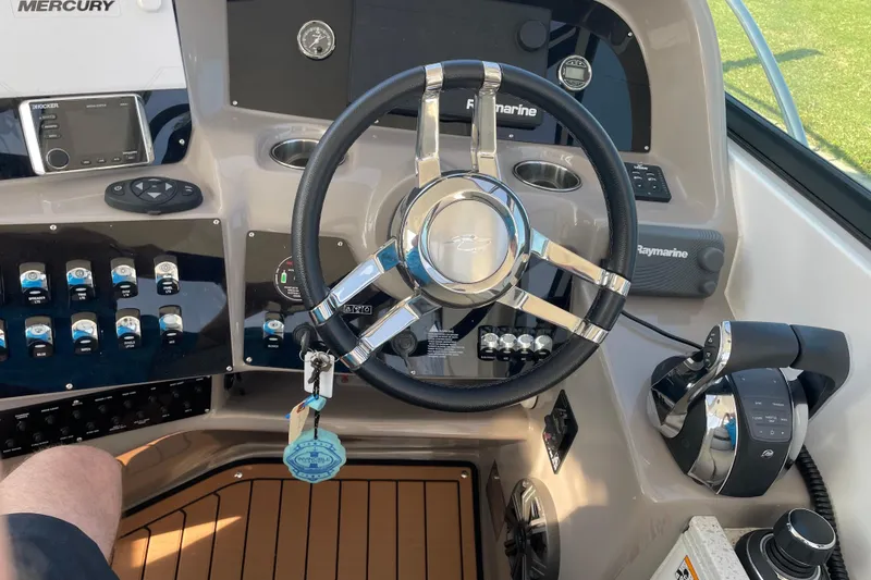 Slide: The Image of 2019 Rinker 370 EX boat dashboard with steering wheel and control panel. - 17