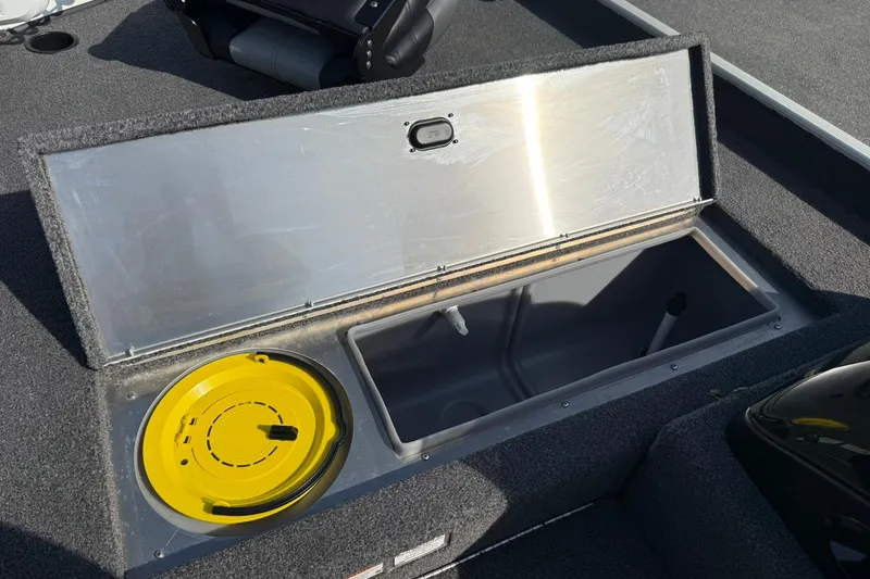 Slide: The Image of Open storage compartment in 2023 Crestliner 1700 Storm boat, featuring a yellow lid. - 13