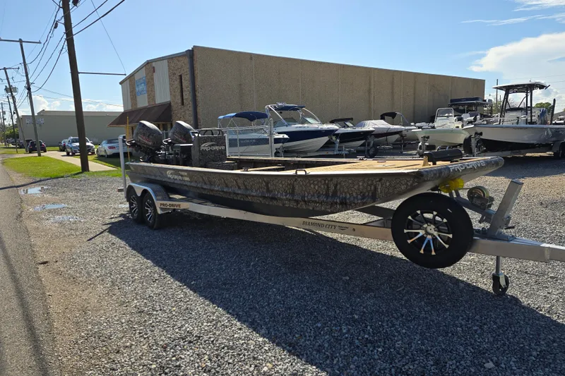 Slide: The Image of Trailered Pro-Drive 2272 boat, 2026 model, parked on gravel near other boats. - 8