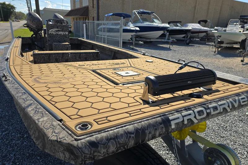 Slide: The Image of Pro-Drive 2272 boat, 2026 model, with hexagonal deck pattern, parked near other boats. - 9