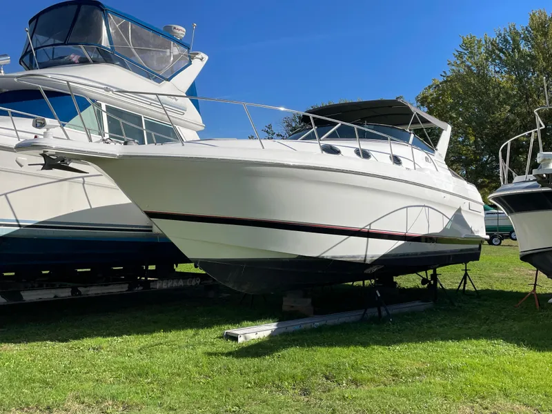 The Image of 1999 Wellcraft 3600 Martinique boat on display, parked on grass under clear blue sky. - 0