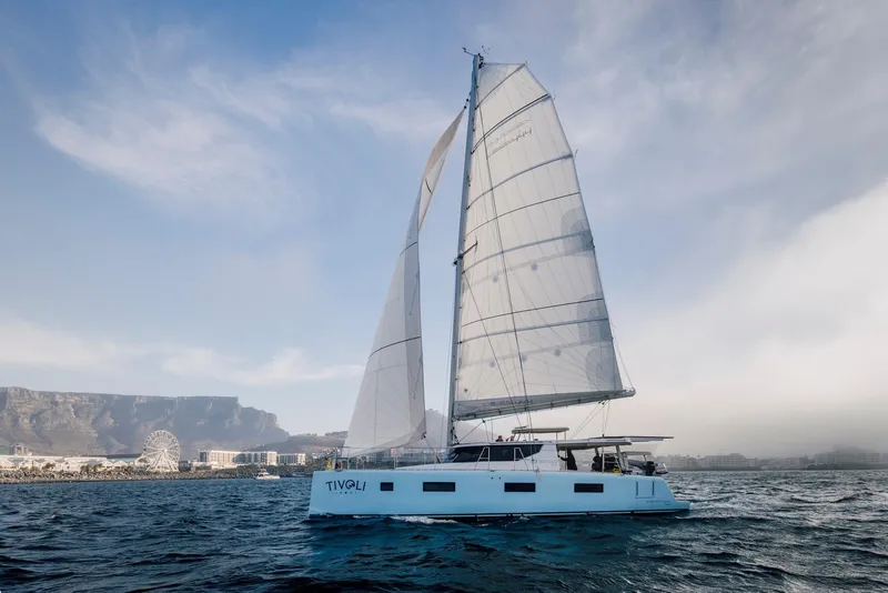 Slide: The Image of Modern Vision 444 sailboat cruising near a coastal city, 2025 model. - 11