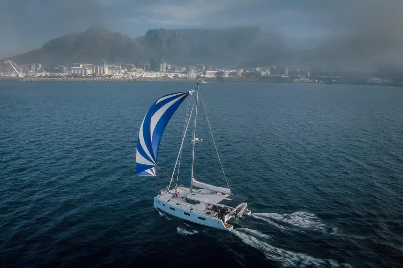 Slide: The Image of Sailing yacht Vision 444 (2025) on open sea with coastal city and mountains in background. - 9