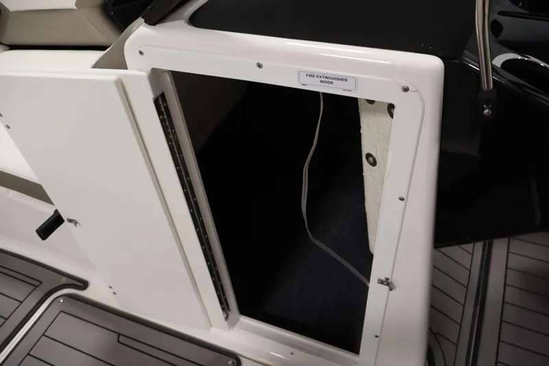 Slide: The Image of Open storage compartment on 2017 Yamaha Boats 212 Limited S, labeled for fire extinguisher. - 18