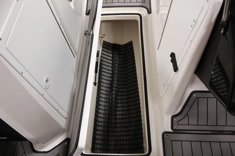 Slide: The Image of 2017 Yamaha Boats 212 Limited S storage compartment with open hatch and black mat. - 35