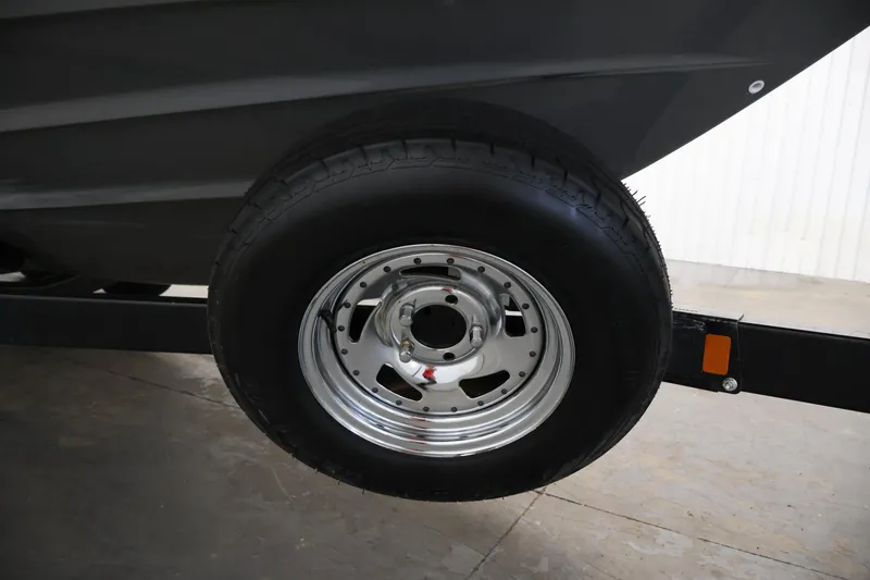 Slide: The Image of Trailer wheel of 2017 Yamaha Boats 212 Limited S in a garage setting. - 46