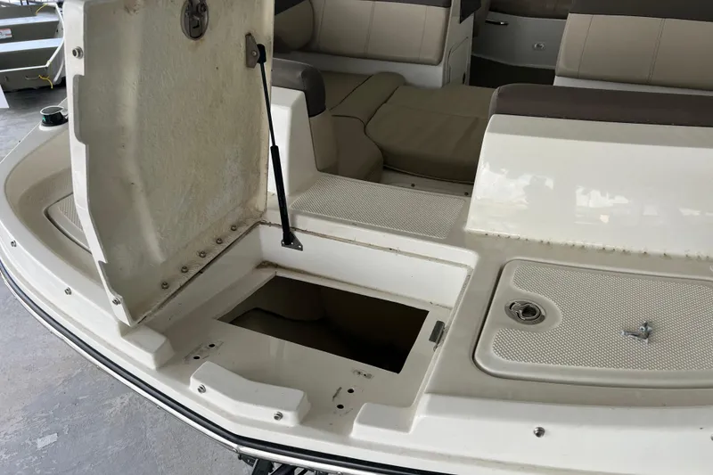 Slide: The Image of 2017 Bayliner 195 Deck Boat interior with open storage compartment and seating area. - 14