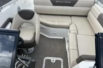 Slide: The Image of 2017 Bayliner 195 Deck Boat interior with beige seating and steering console. - 3