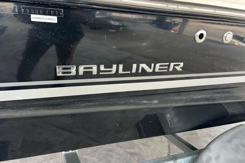 Slide: The Image of Bayliner 195 Deck Boat 2017, black hull with logo, assembled in Mexico. - 9