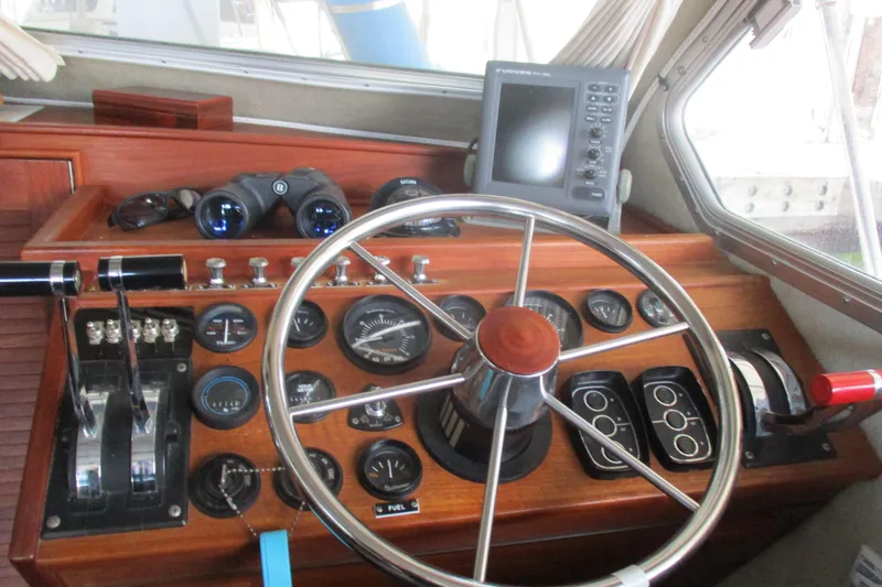 Slide: The Image of 1988 Commander 26 boat helm with steering wheel, gauges, and navigation equipment. - 19