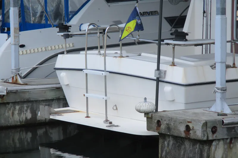 Slide: The Image of 1988 Commander 26 boat docked, featuring a ladder and a colorful flag at the stern. - 5