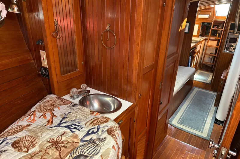 Slide: The Image of Cozy 1985 Kadey-Krogen 38 yacht interior with wood paneling and nautical-themed bedding. - 11