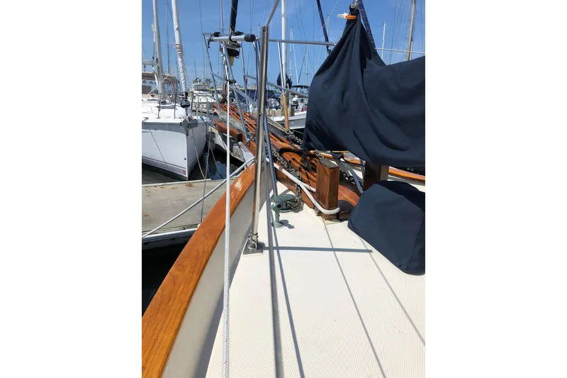 Slide: The Image of 1985 Kadey-Krogen 38 sailboat deck with wooden railings and covered equipment. - 14