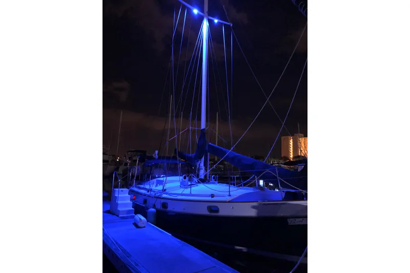 Slide: The Image of 1985 Kadey-Krogen 38 sailboat illuminated by blue lights at night in a marina. - 19