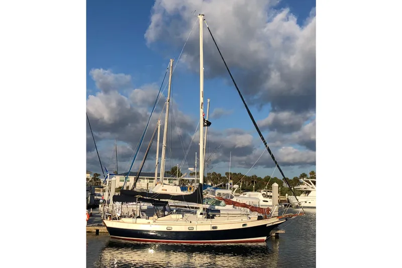Slide: The Image of 1985 Kadey-Krogen 38 sailboat docked at marina under cloudy sky. - 2