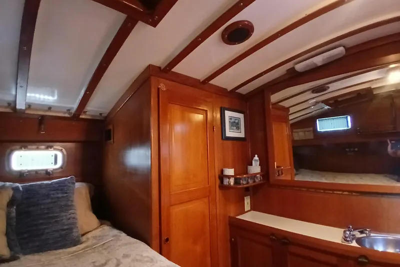 Slide: The Image of Cozy 1985 Kadey-Krogen 38 cabin interior with wooden finish and porthole window. - 28