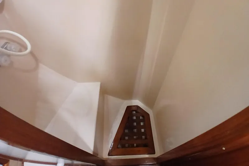 Slide: The Image of Interior of 1985 Kadey-Krogen 38 boat, featuring a wooden grate and beige walls. - 39