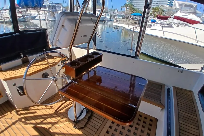 Slide: The Image of Cockpit of 1985 Kadey-Krogen 38 yacht with wooden table and steering wheel. - 51
