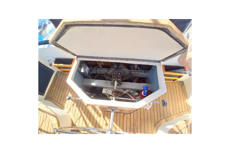 Slide: The Image of Open engine compartment of 1985 Kadey-Krogen 38 boat, showcasing mechanical components on wooden deck. - 70