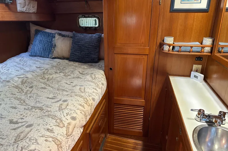 Slide: The Image of Cozy cabin interior of 1985 Kadey-Krogen 38 with bed, wooden cabinetry, and sink. - 8