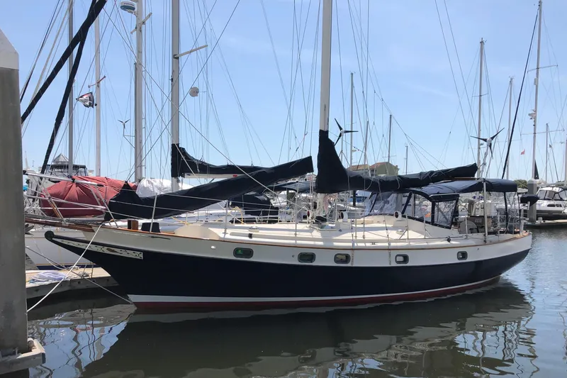 Slide: The Image of 1985 Kadey-Krogen 38 sailboat docked in a marina, featuring classic design and rigging. - 85
