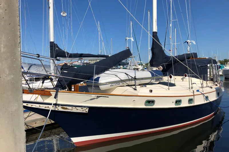 Slide: The Image of 1985 Kadey-Krogen 38 sailboat docked in a marina under clear blue skies. - 86
