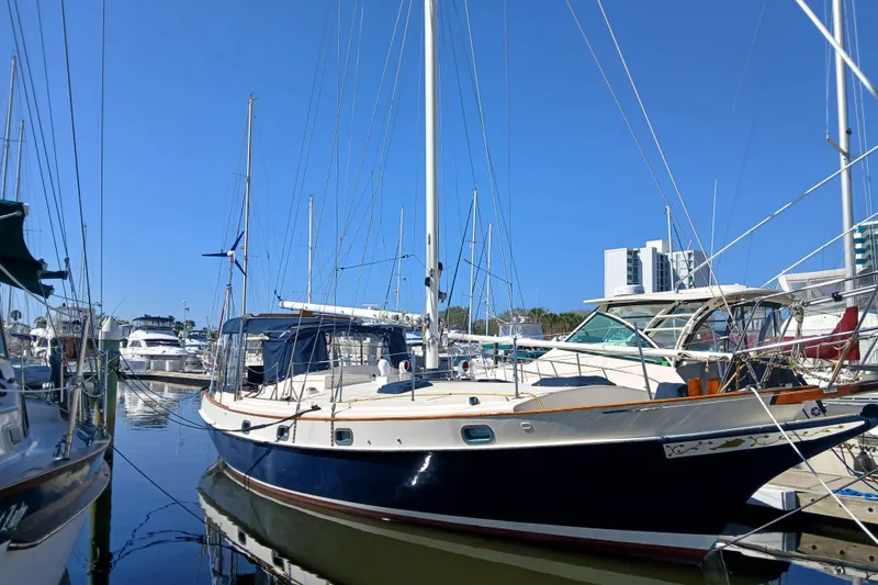 Slide: The Image of 1985 Kadey-Krogen 38 sailboat docked at marina under clear blue sky. - 88
