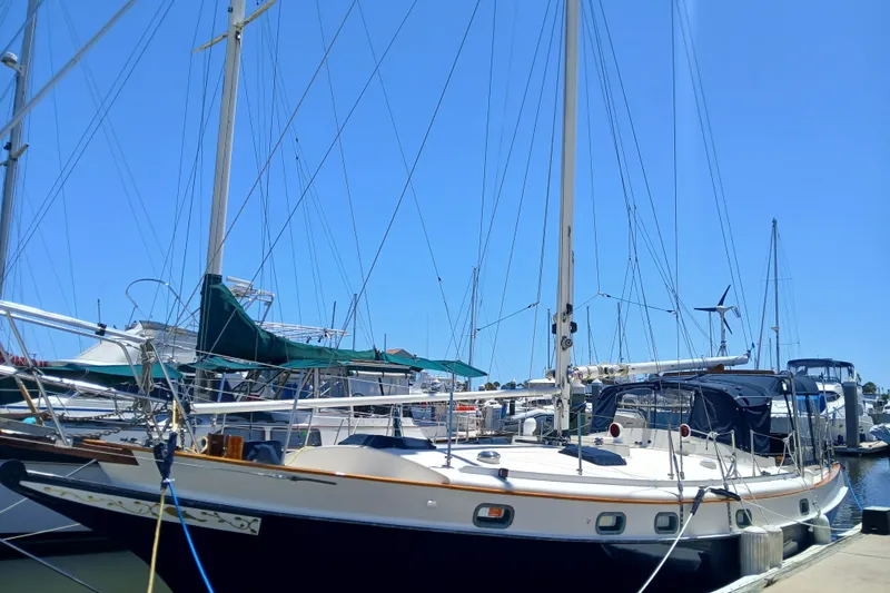 Slide: The Image of 1985 Kadey-Krogen 38 sailboat docked at a marina under clear blue skies. - 91