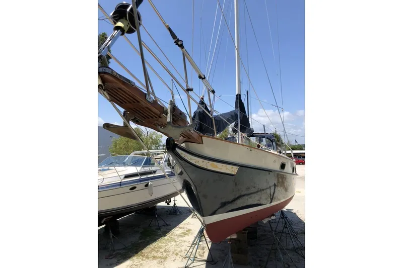 Slide: The Image of 1985 Kadey-Krogen 38 sailboat on dry dock, viewed from the bow under a clear sky. - 92