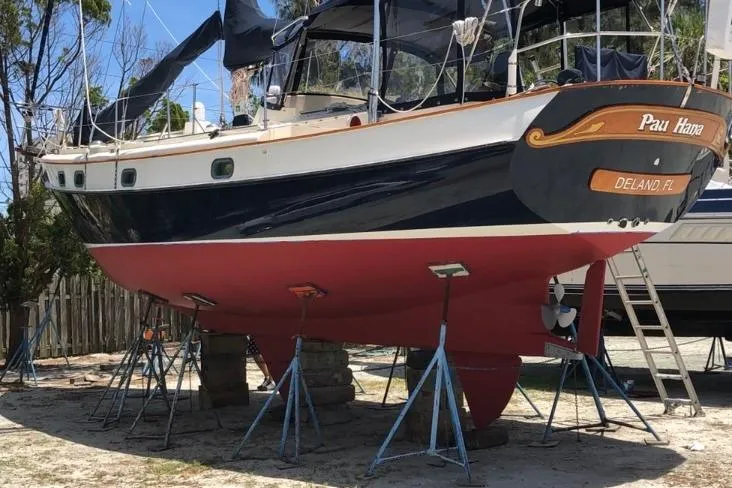 Slide: The Image of Kadey-Krogen 38 yacht from 1985 on stands, with a red hull and blue upper section. - 94