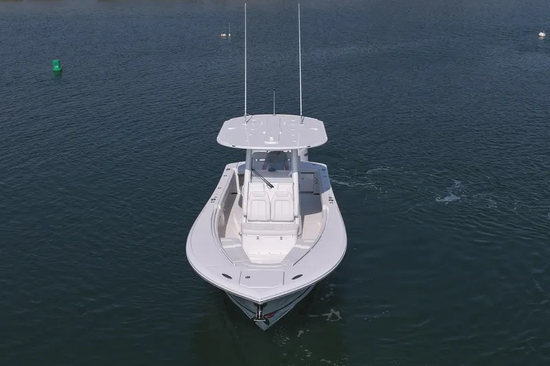 Slide: The Image of 2026 Regulator 28 boat on calm water, front view with T-top and seating. - 12