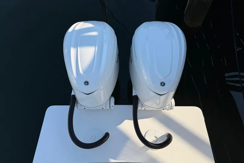 Slide: The Image of Twin outboard engines on a 2026 Regulator 28 boat, docked on calm water. - 17