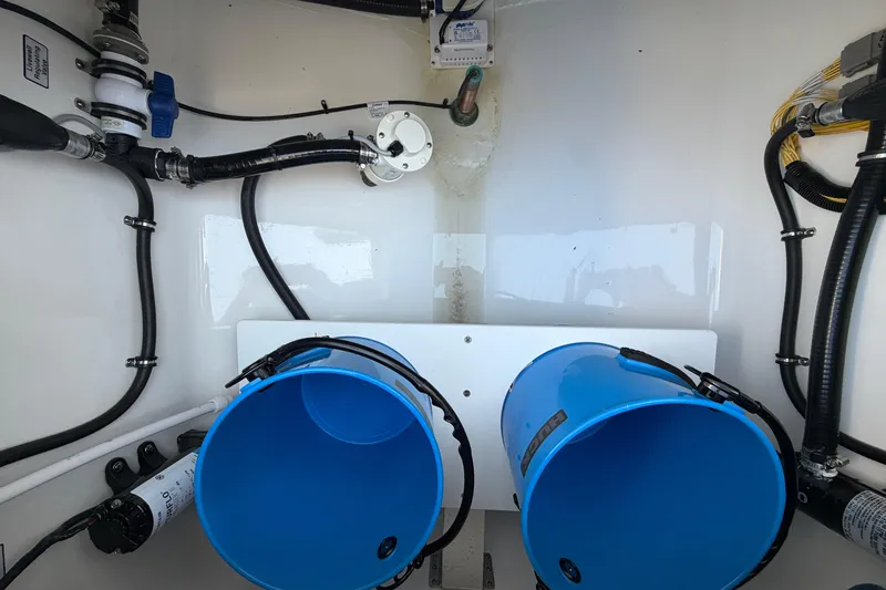 Slide: The Image of Interior view of a 2026 Regulator 28 boat showing plumbing and blue buckets. - 26