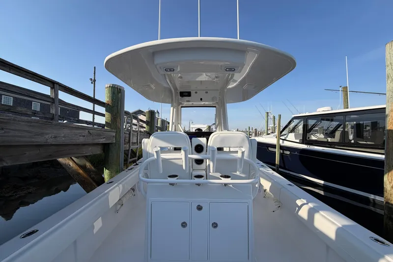 Slide: The Image of 2026 Regulator 28 boat docked, showcasing helm and seating area under clear blue sky. - 27