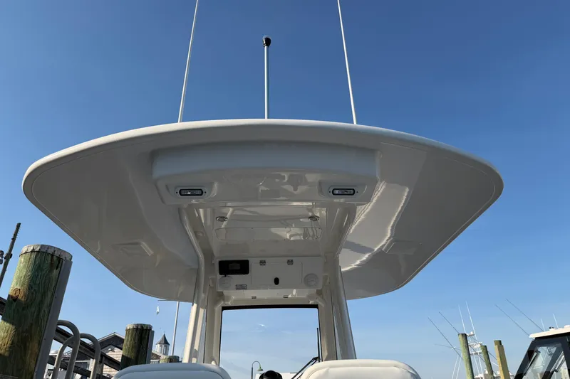 Slide: The Image of 2026 Regulator 28 boat's T-top against clear blue sky at marina. - 28
