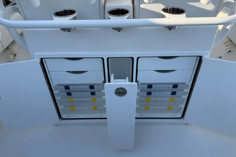 Slide: The Image of 2026 Regulator 28 boat storage compartments with organized tackle boxes and cup holders. - 30