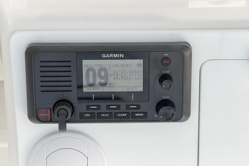 Slide: The Image of Garmin marine radio on 2026 Regulator 28 boat dashboard, displaying channel and coordinates. - 36