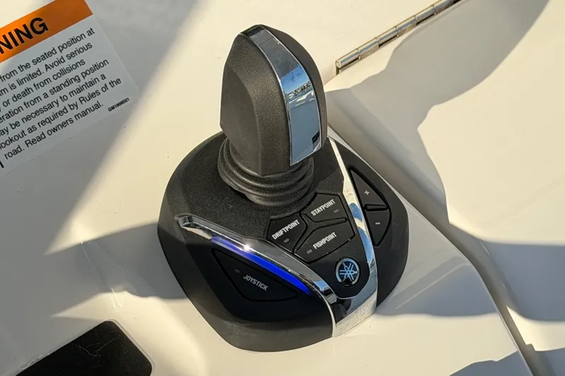 Slide: The Image of Joystick control on 2026 Regulator 28 boat dashboard with warning label. - 42