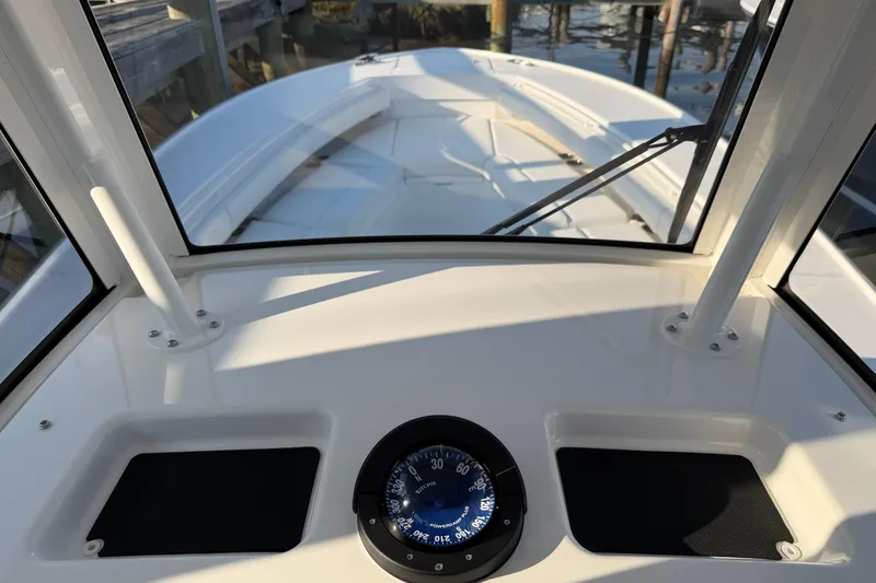 Slide: The Image of 2026 Regulator 28 boat dashboard with compass, docked by the water. - 48