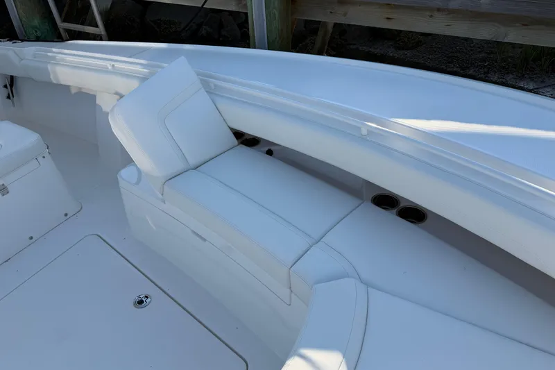 Slide: The Image of 2026 Regulator 28 boat interior with white cushioned seating and cup holders. - 55
