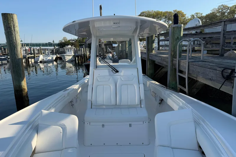 Slide: The Image of 2026 Regulator 28 boat docked at marina, showcasing sleek design and spacious seating. - 58